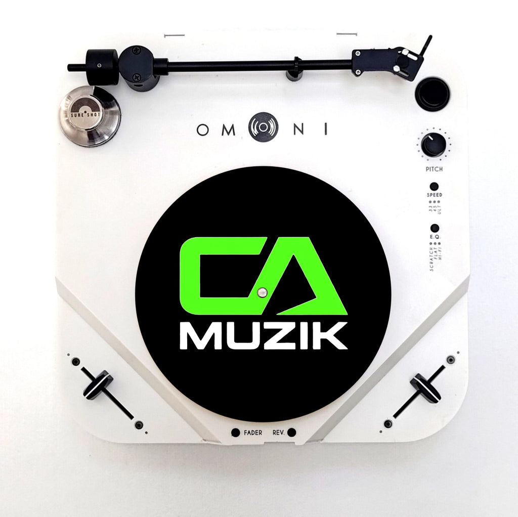 Black CA Muzik slipmat with green CA logo and white MUZIK lettering, shown on a white turntable